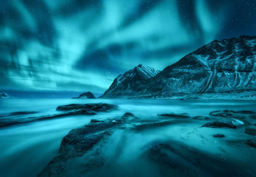 Aurora boreal azul con montañas