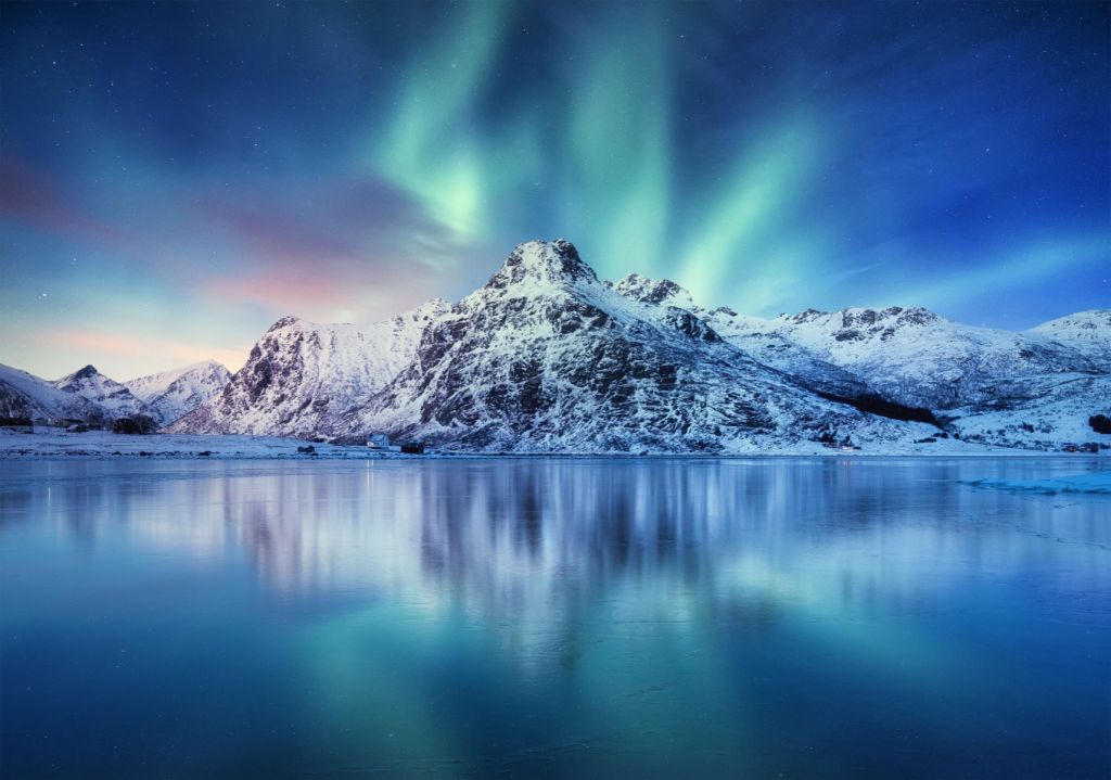 Auroras boreales sobre un océano y montañas heladas