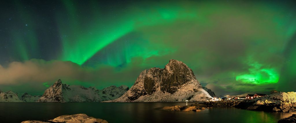 Aurora boreal sobre una alta montaña