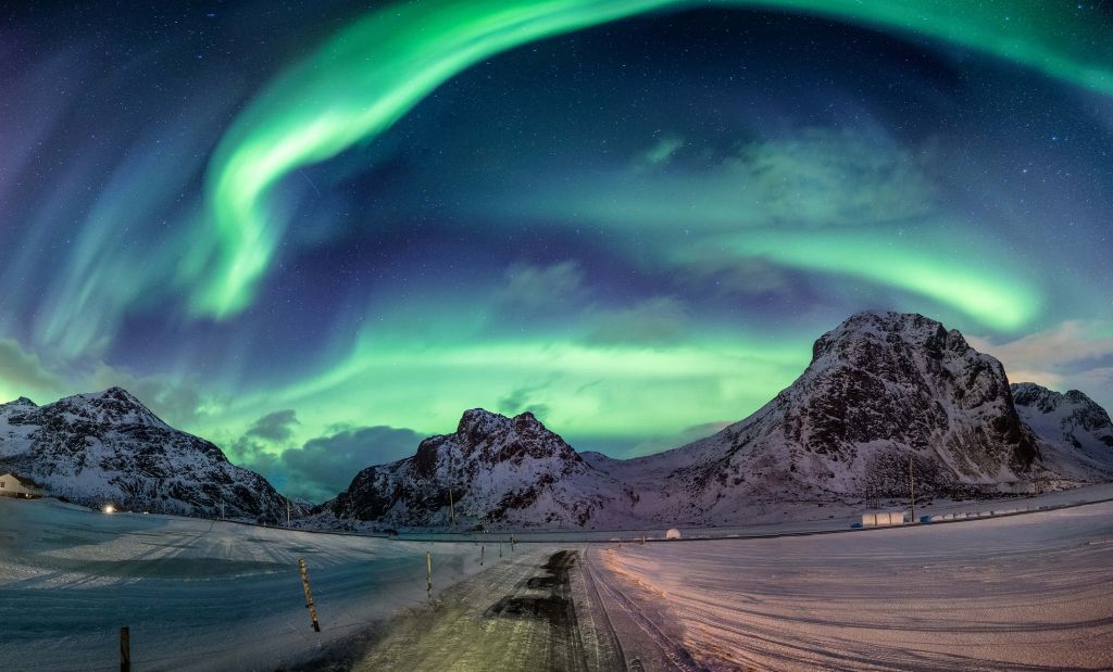 Aurora boreal sobre montañas nevadas