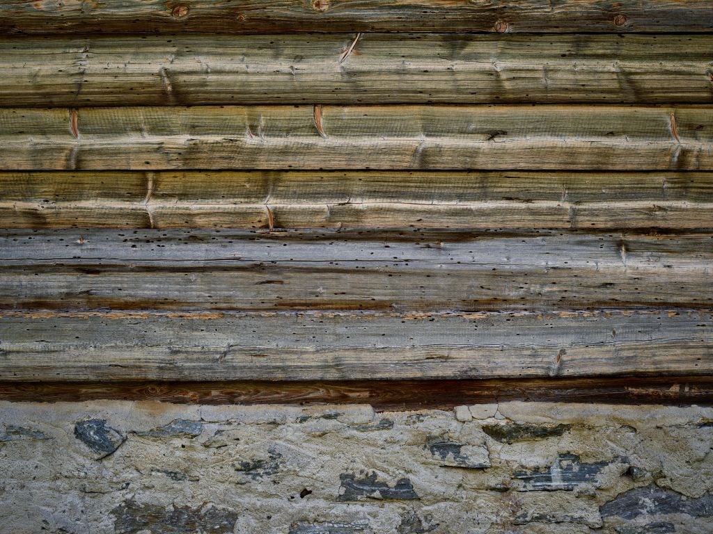 Madera desgastada sobre muro de piedra