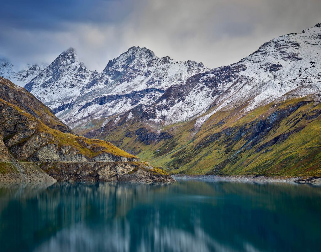 Picos de montaña con nieve cerca de un lago de montaña