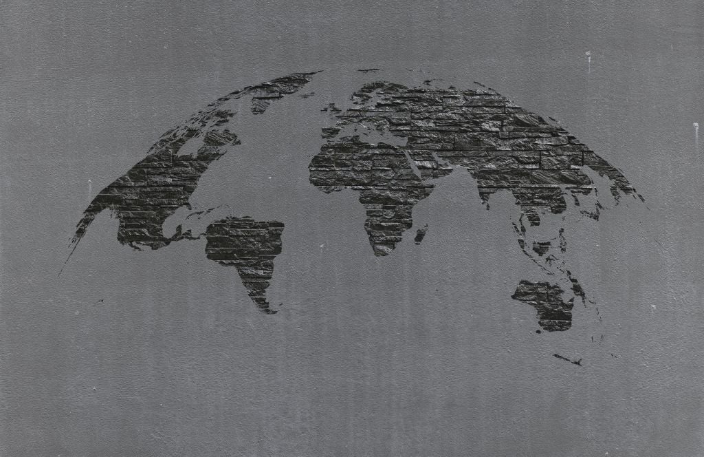 Piedras del mapa del mundo sobre hormigón gris