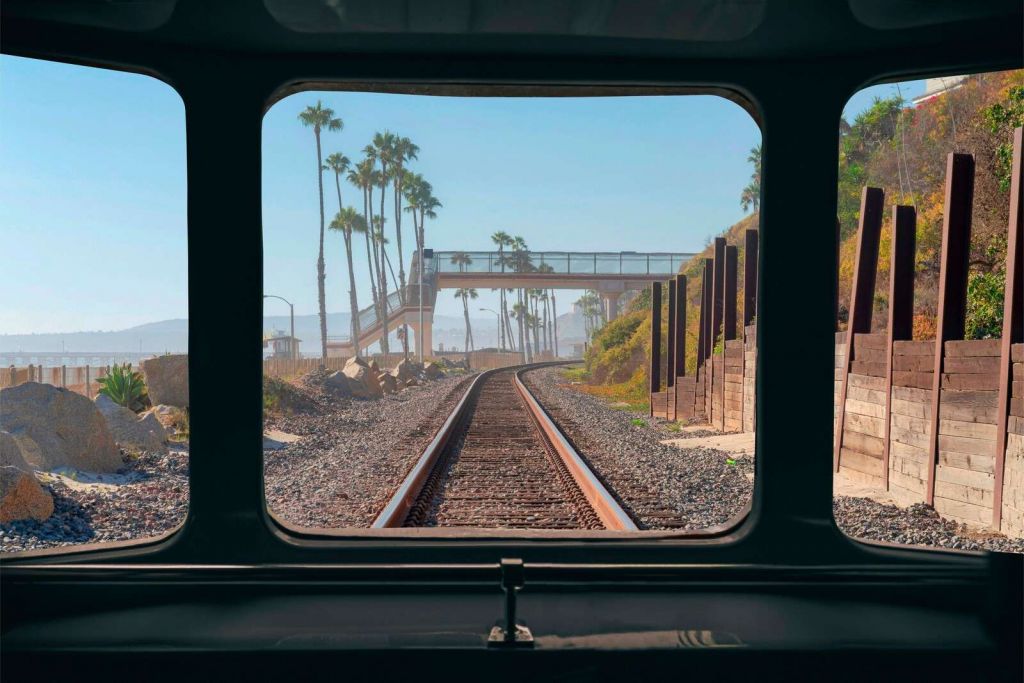 Línea de ferrocarril a lo largo de la costa de palmeras
