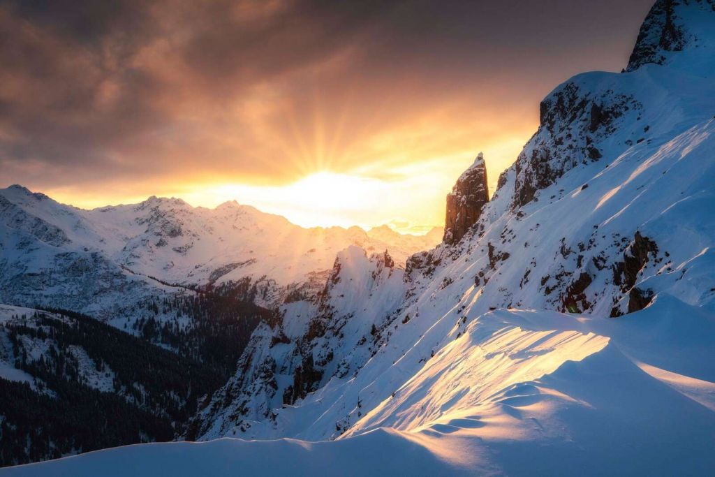 Sol de la tarde detrás de las cumbres nevadas