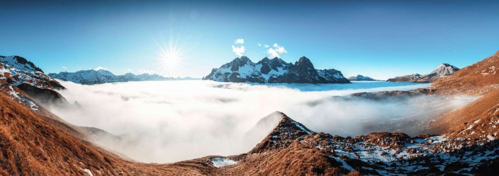 Valle de montaña bañado por el sol con mar de nubes