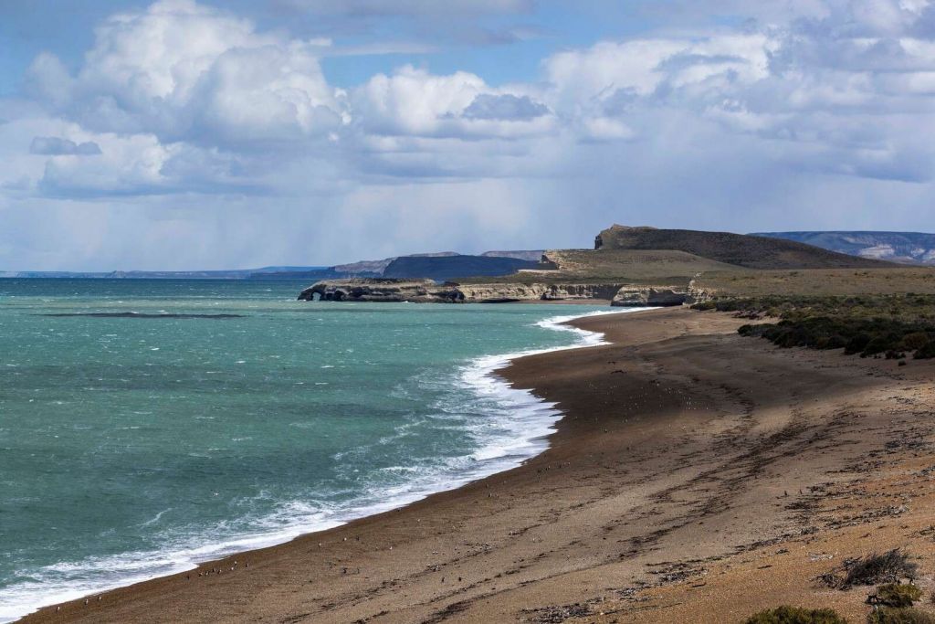 Acantilado rugoso con mar turquesa.