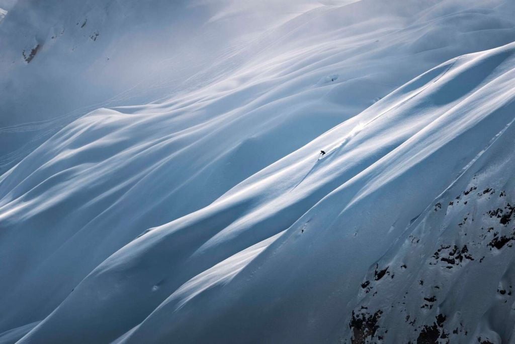 Descenso de freeride en una pendiente de nieve en polvo