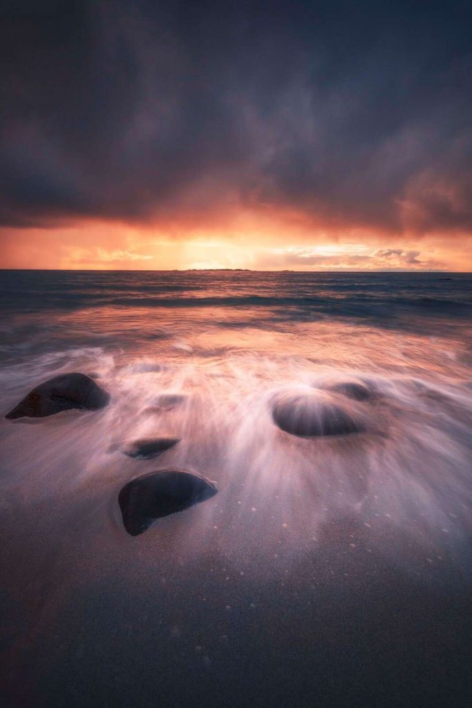 Resplandor del atardecer sobre la costa de piedra