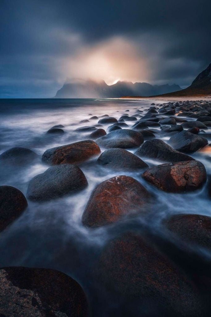 Luz de la tarde sobre una costa de rocas ásperas.