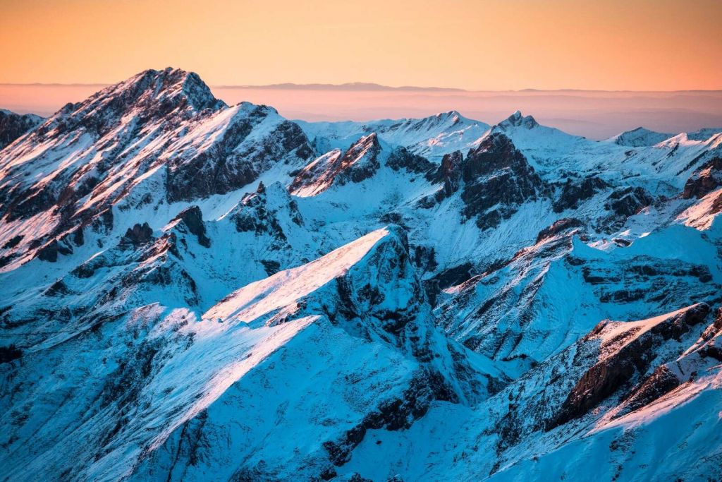 Amanecer sobre una cordillera nevada.