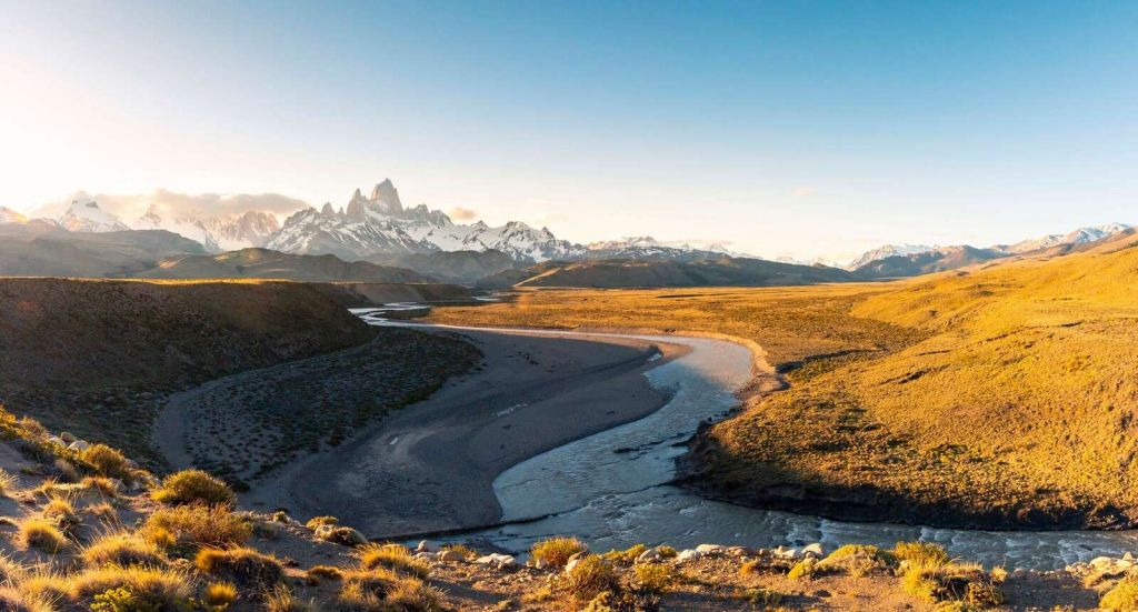 Paisaje de montaña con río serpenteante en la luz de la mañana.