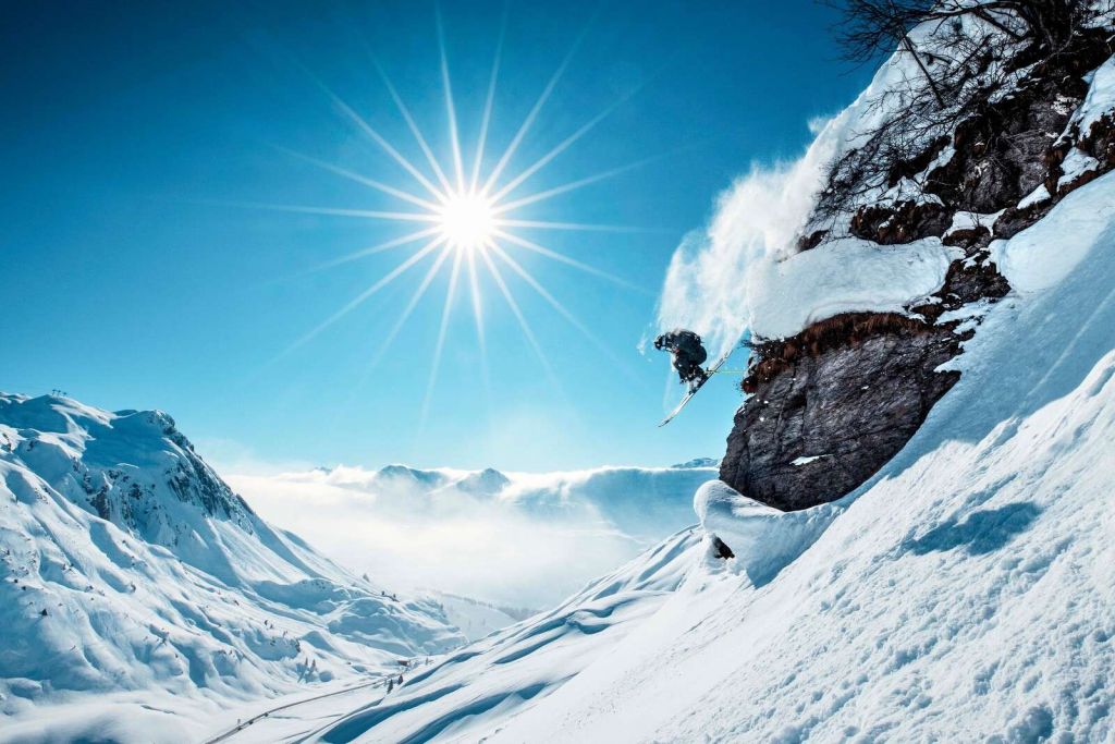 Salto libre en un paisaje nevado bañado por el sol.