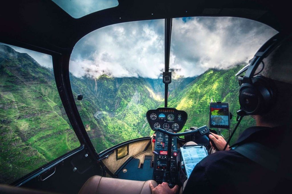 Vuelo en helicóptero sobre un valle de montaña tropical.