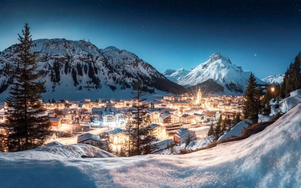Pueblo alpino brillante bajo el cielo estrellado.