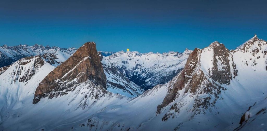 Luz de luna sobre picos alpinos.