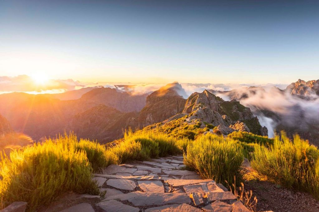 Amanecer sobre sendero de montaña y nubes