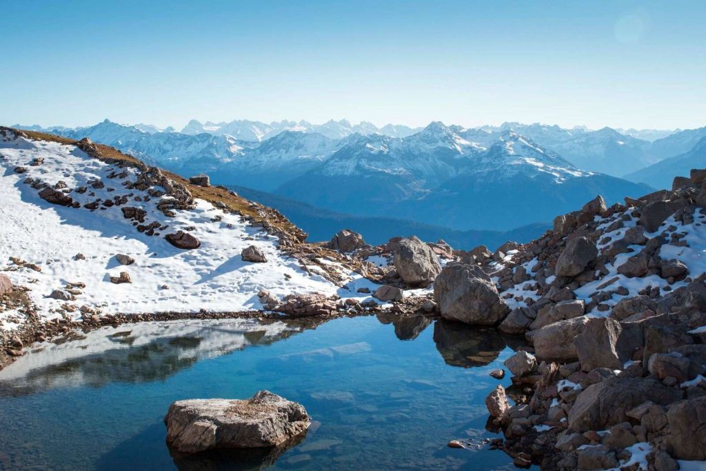 Lago de montaña entre cumbres nevadas.
