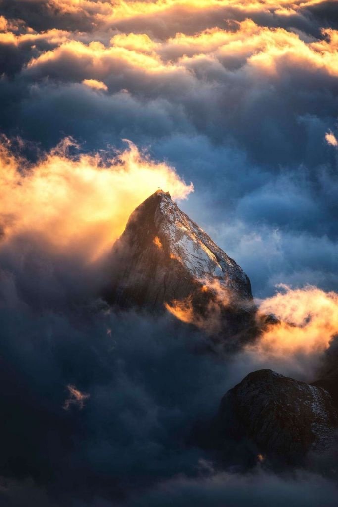 Cruz de montaña en niebla ardiente.