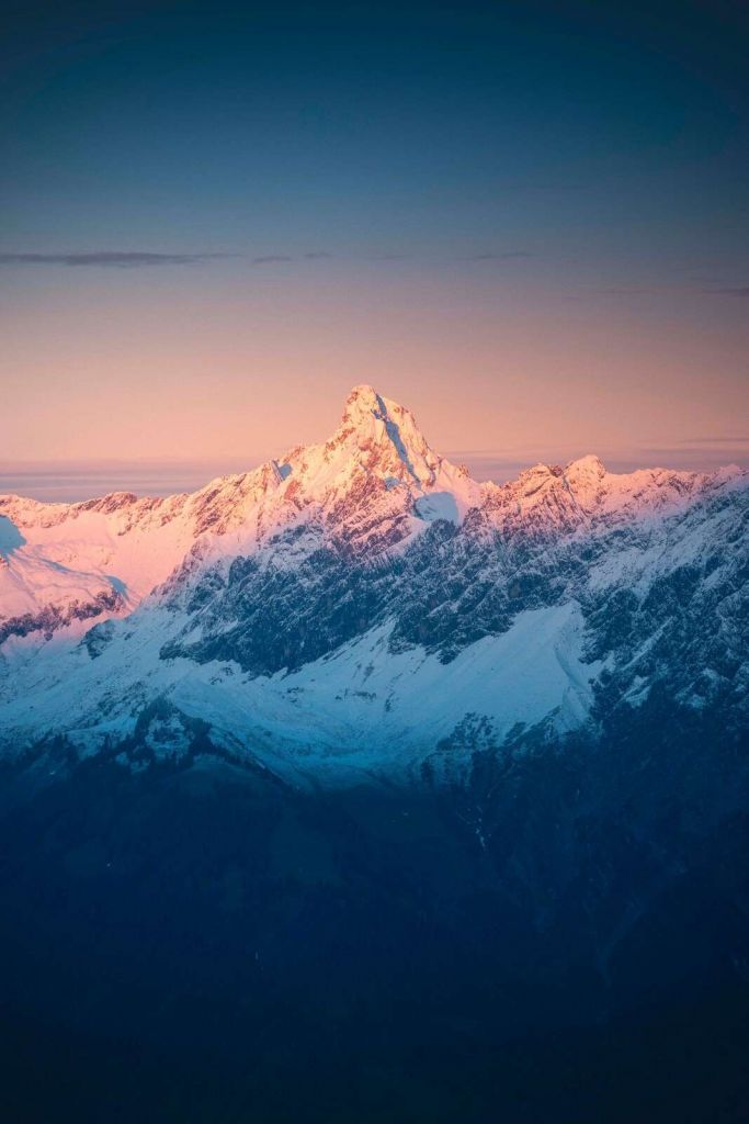 Luz de la tarde en la cima nevada de la montaña.