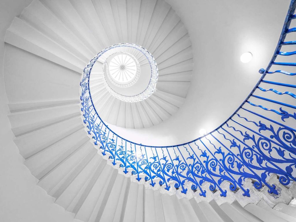 Escalera de caracol blanca con barandilla azul