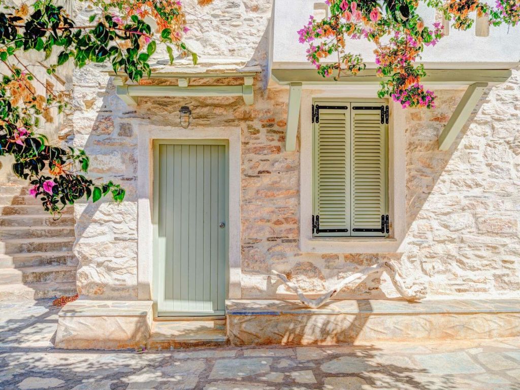 Fachada de piedra mediterránea con buganvilla