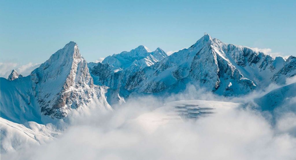 Picos monta√±osos nevados en la niebla