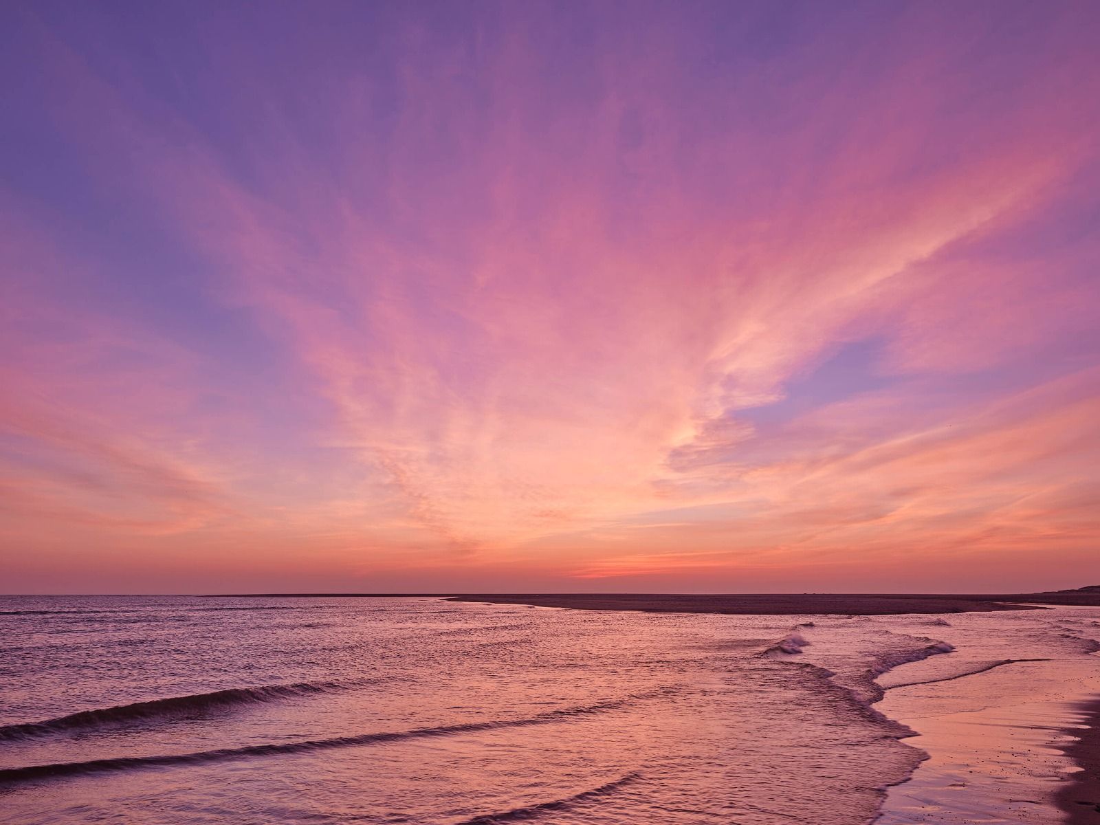 Playa con puesta de sol rosa