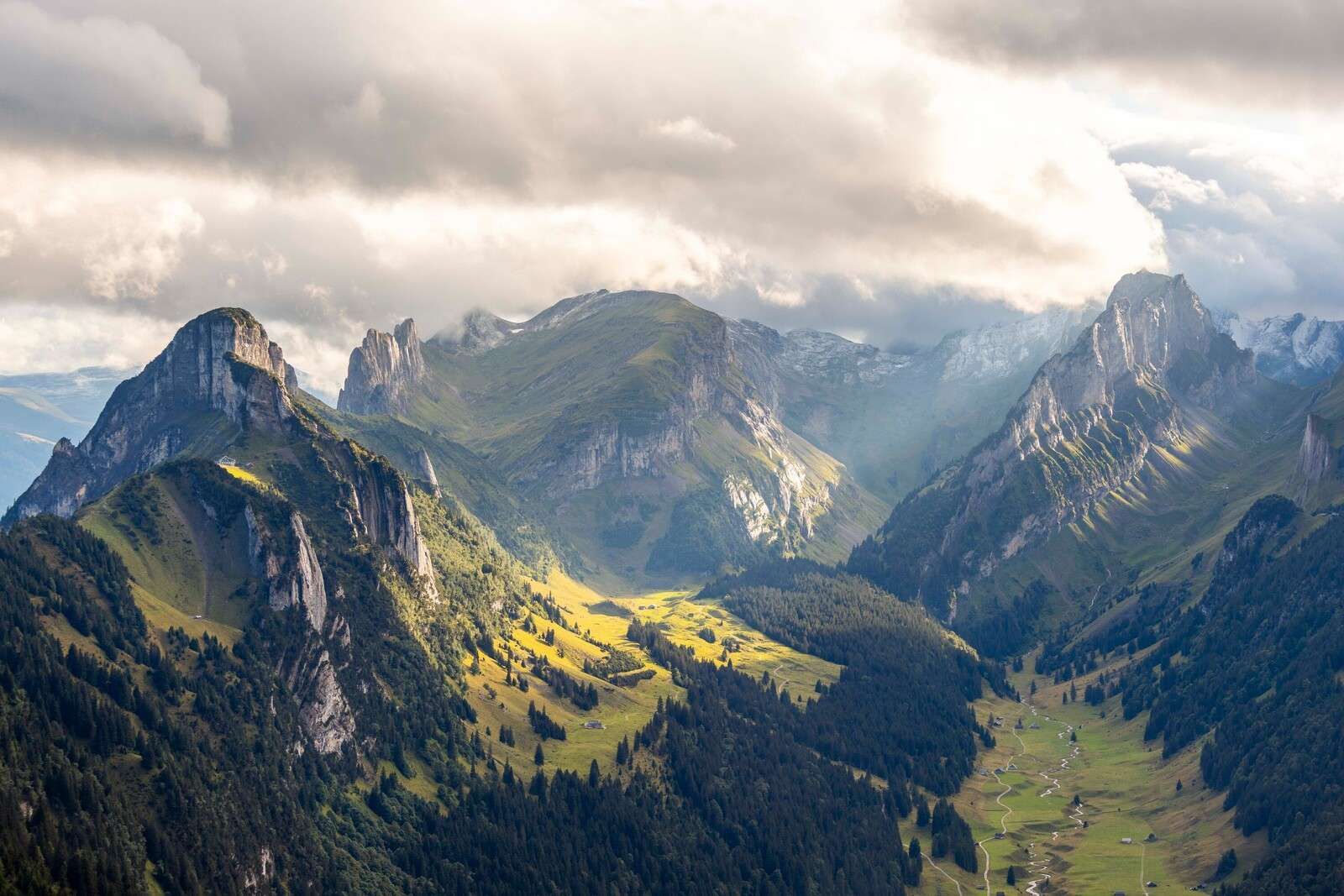 Luz del sol sobre un valle de montaña verde.