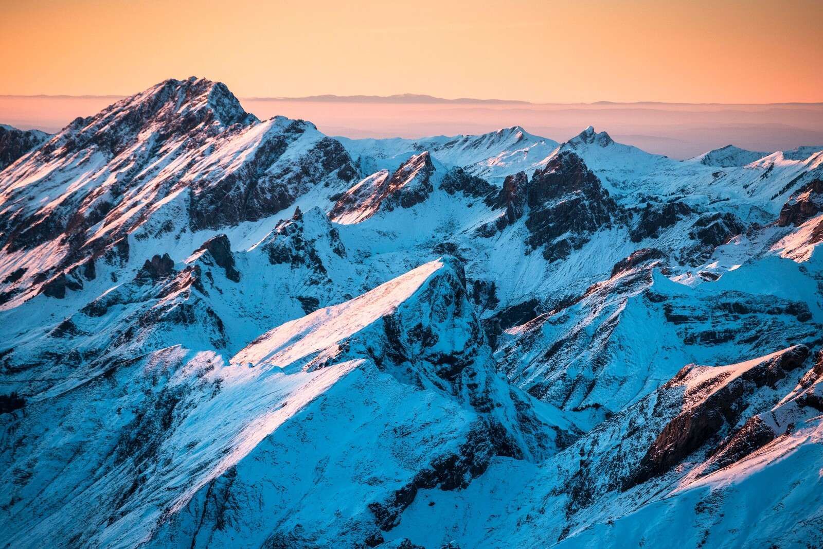 Amanecer sobre una cordillera nevada.