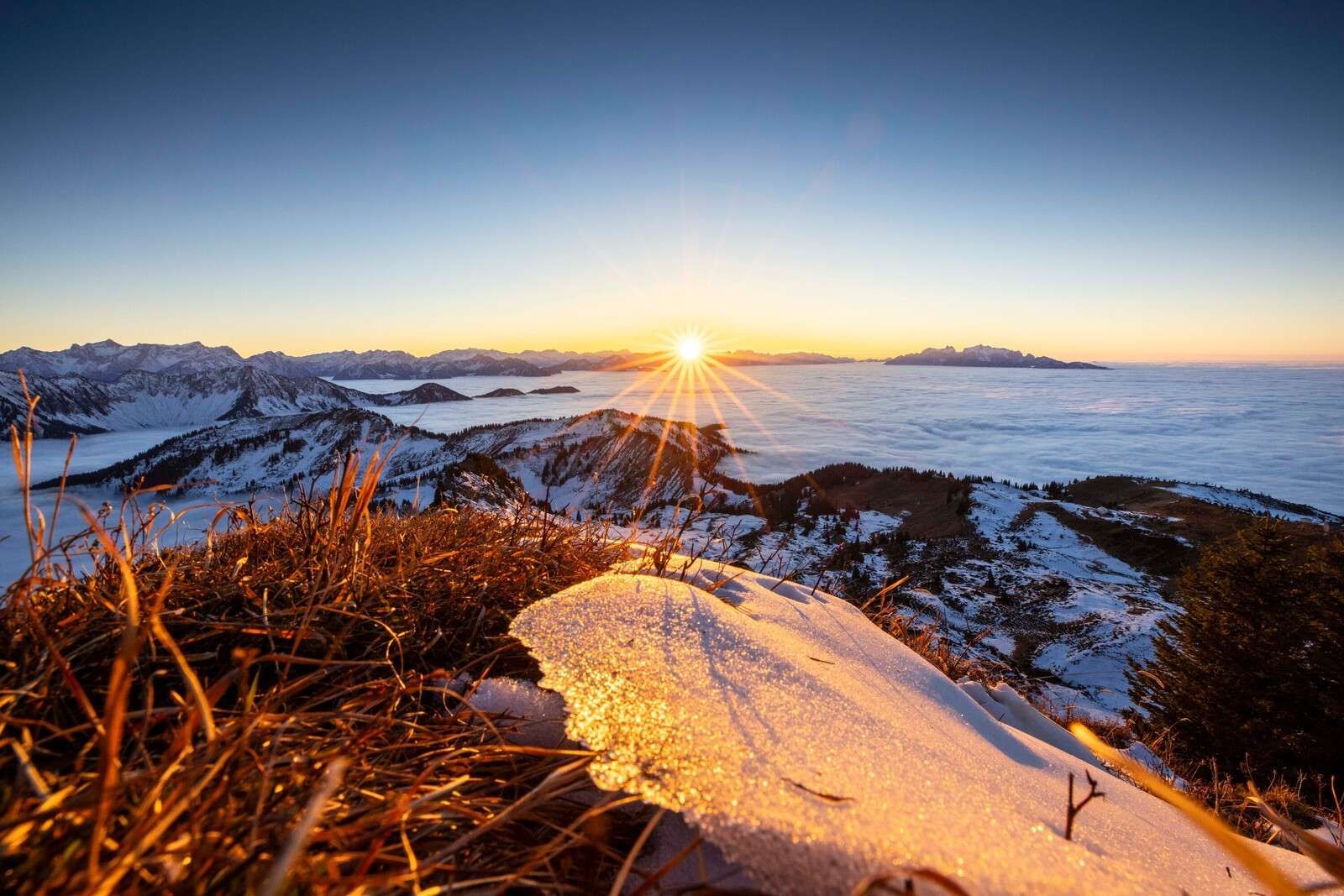Amanecer sobre prado de montaña invernal