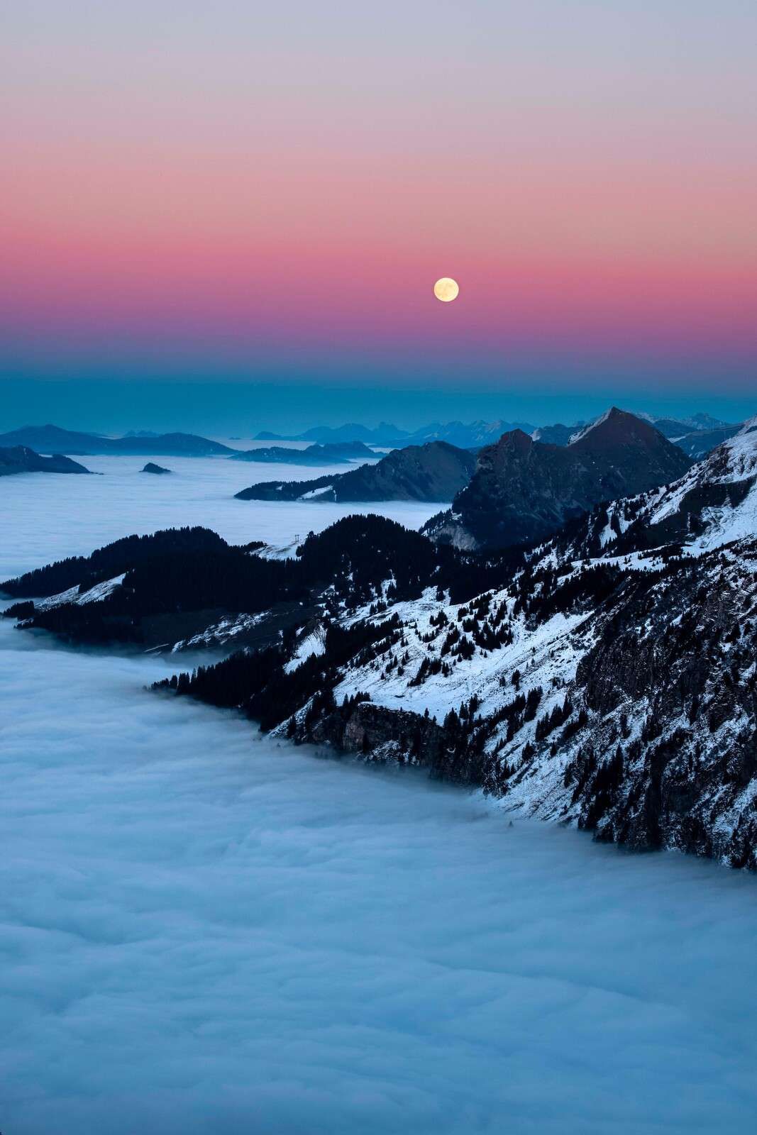 Luz de luna sobre montañas invernales.