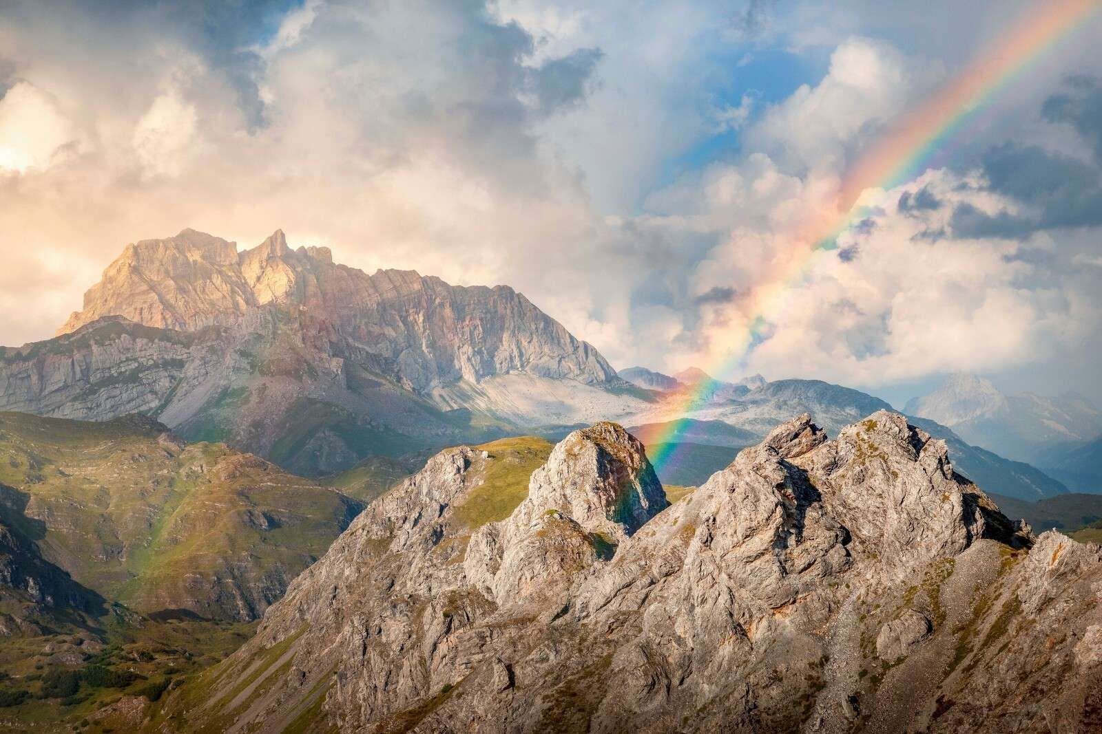 Luz del arco iris sobre montañas escarpadas
