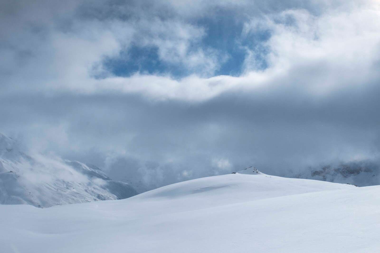 Colinas nevadas bajo un cielo amenazante.