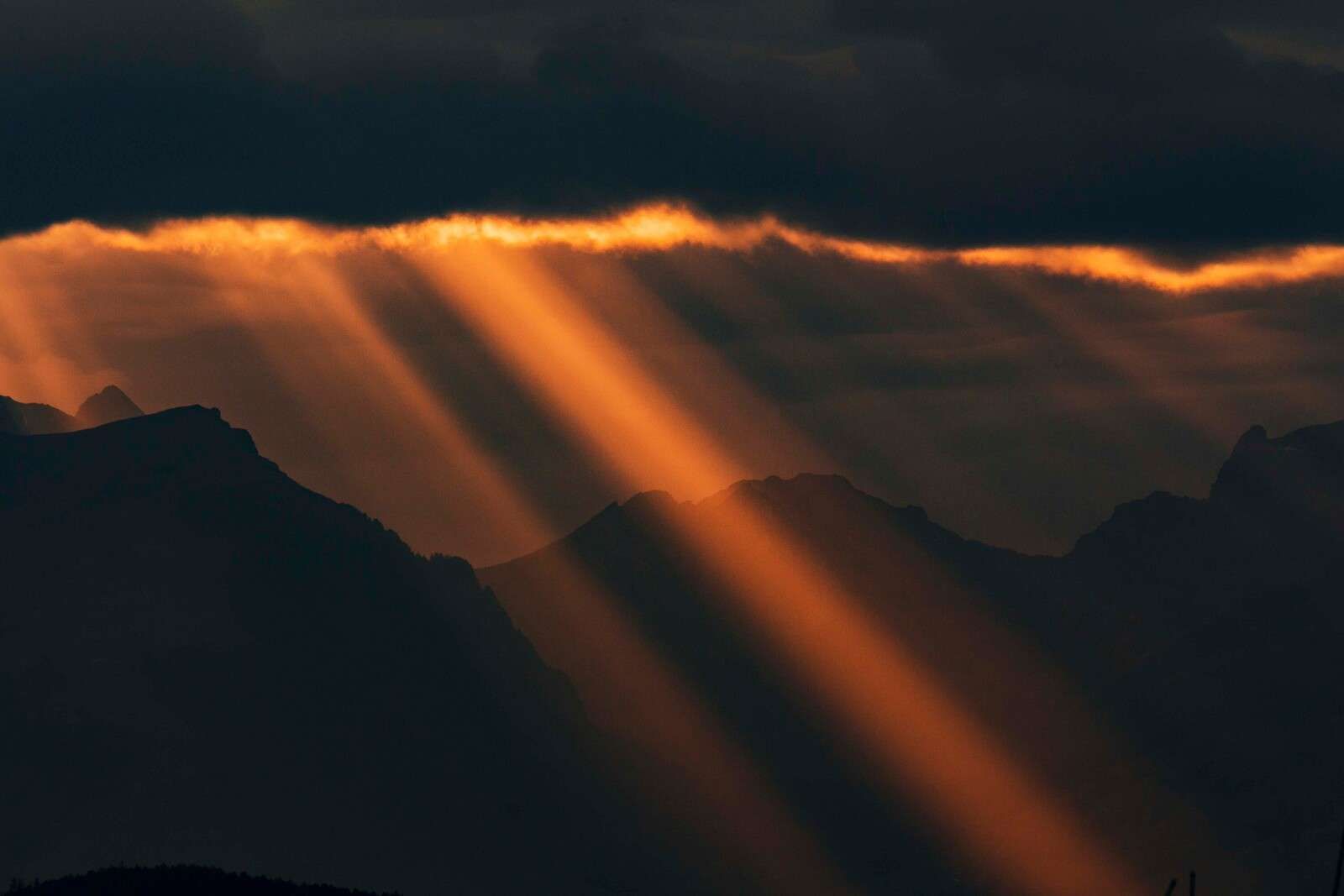 Rayos de sol dorados sobre el perfil de la montaña