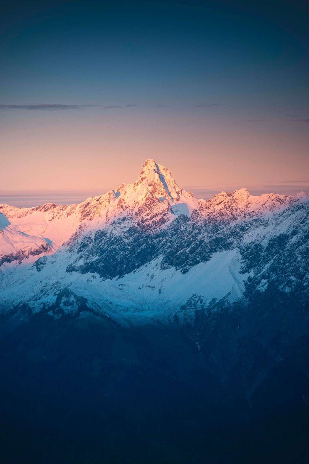 Luz de la tarde en la cima nevada de la montaña.