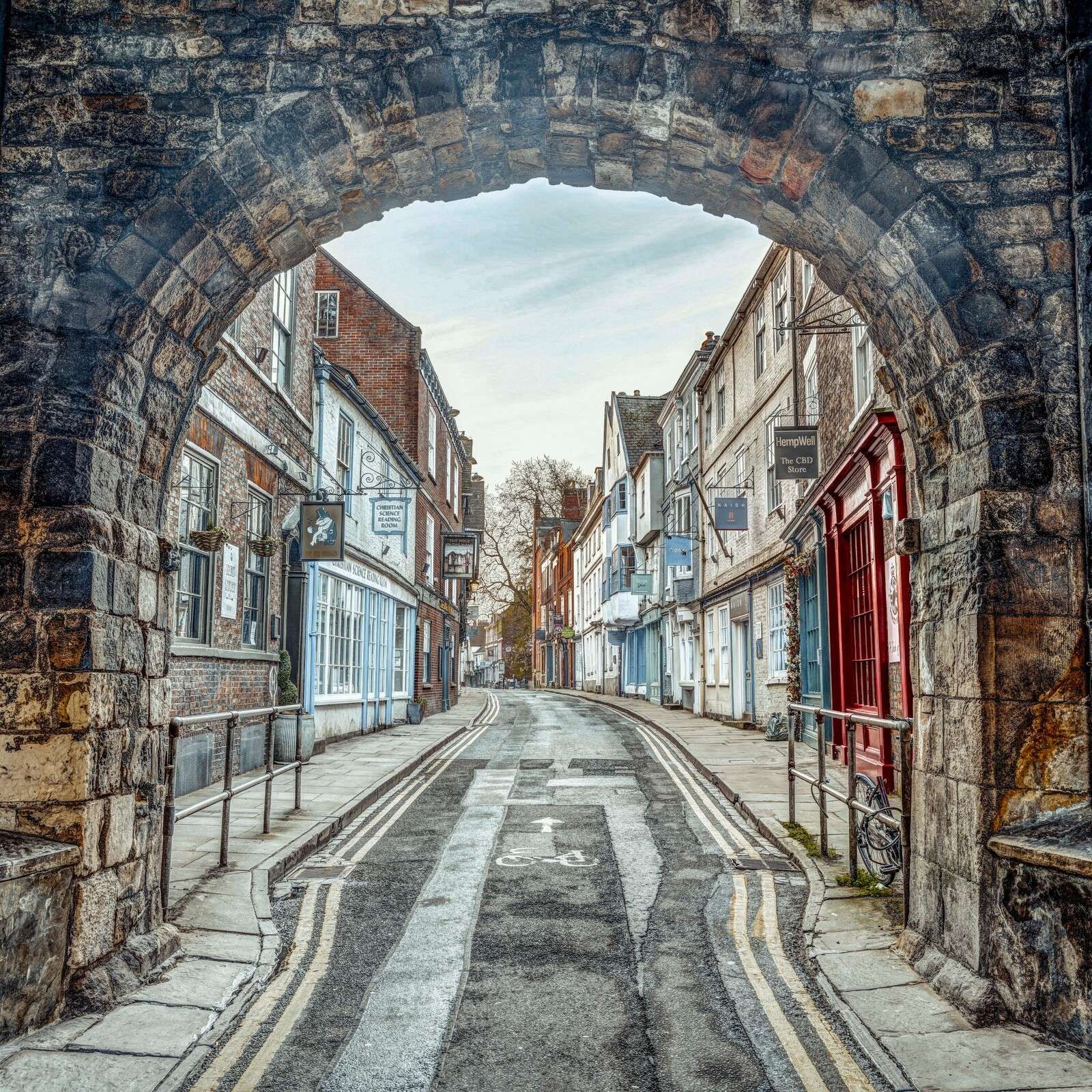 Calle histórica bajo un portal de piedra