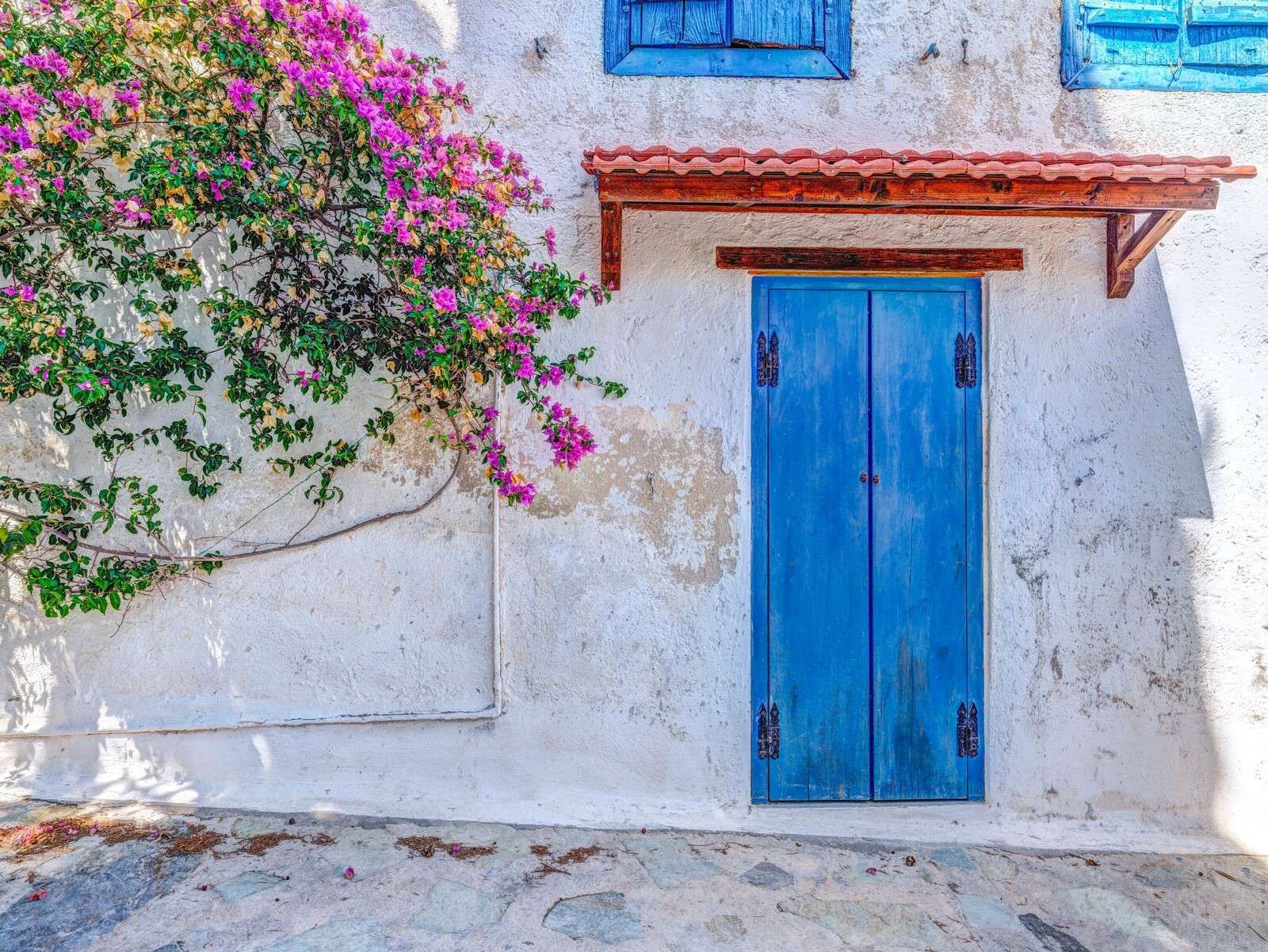 Puerta azul con buganvilla