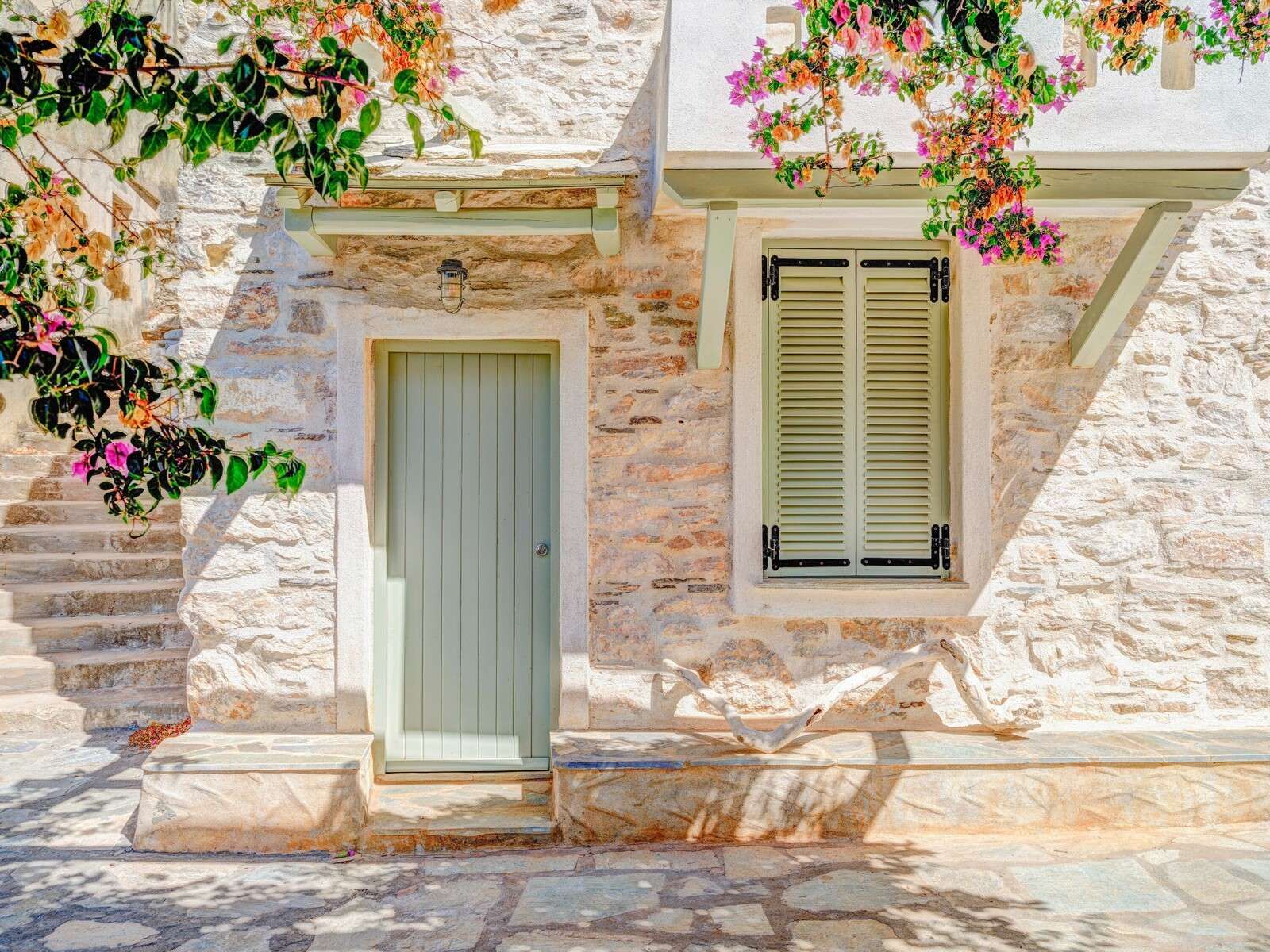Fachada de piedra mediterránea con buganvilla