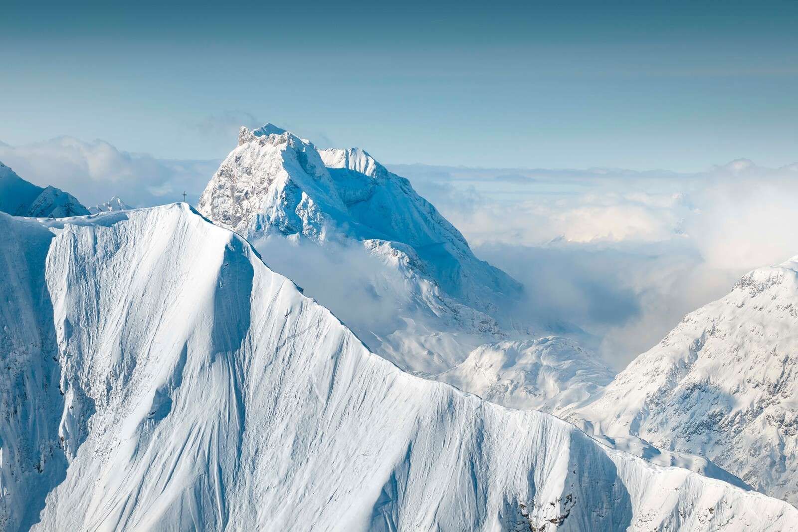 Monta√±as nevadas sobre un manto de nubes